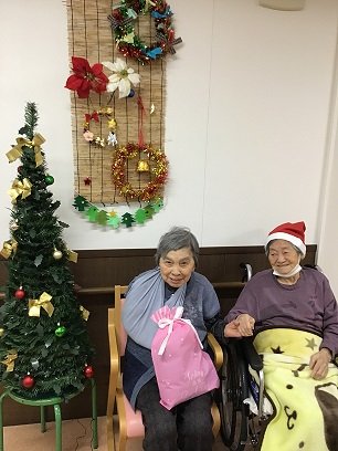 入居者様がお誕生日会でプレゼントをもらっている様子
