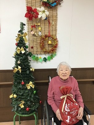 入居者様がお誕生日会でプレゼントをもらっている様子